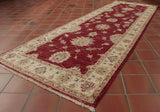 With its red background and cream border this Afghan runner has a welcoming look.