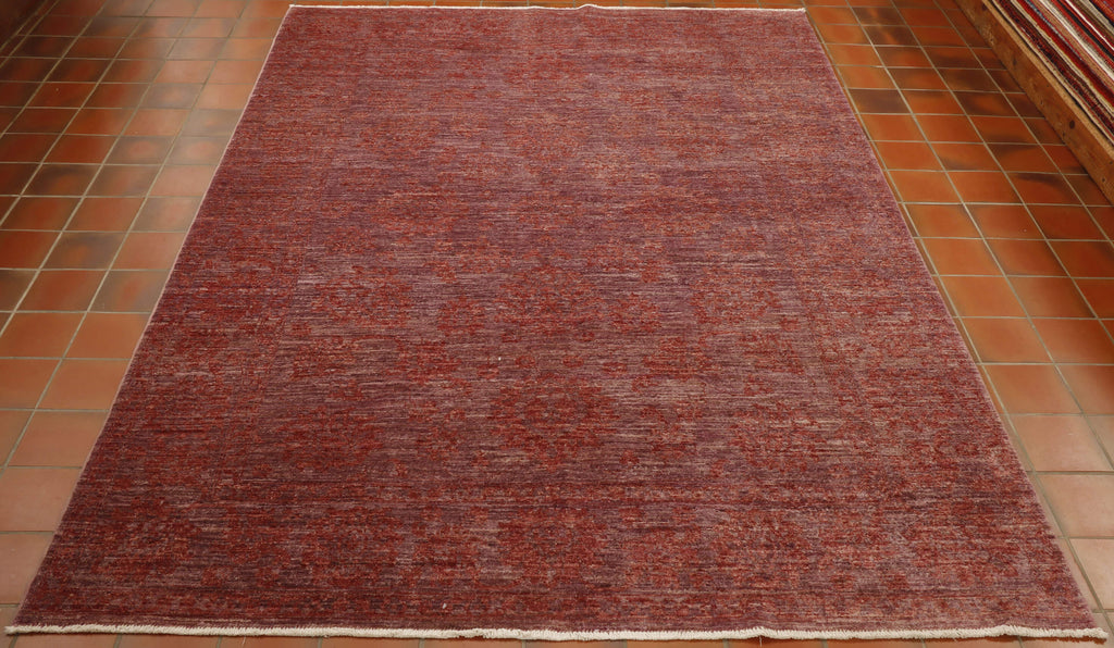 Purple red ground to the entirety of this rug with the decoration being floral executed in a blended red. 