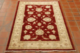 This rug has a bold rusty red ground with a cream ground.  The other colours used within the floral decoration are green, terracotta and blue highlights. 