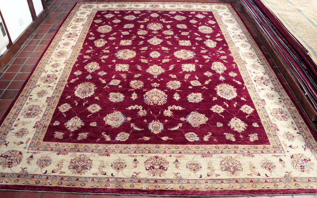 This rich red Afghan Ziegler carpet is a very traditionally styled piece, wiht floral-geometrical patterns and motifs encompassing the majority of the rug.