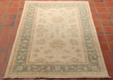 This is a hand knotted Afghan Ziegler in very pale gentle colours. Made from Hand spun Karakul wool, the background is a warm cream colour and the border a soft blue/green shade. There are traces of a soft terracotta used as highlights in the subtle floral design. This is the sort of rug that you could put in your room and it would look as if it had always been there.