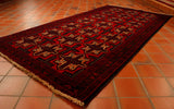 deep red cream and brown colourings have been used in th Afghan Belouch tribal rug