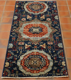Dark blue ground with three large medallions using a pale blue, red and more dark blue.   There are also some areas that use sea green.  The decoration upon the whole of the rug is intricate. 