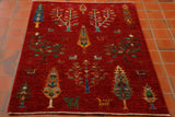 Stunning Afghan Shahi with warm red background and covered in lots of different trees in varying colours of gold, turquoise, blue, green and tan. Random stylised birds and animals have been added to give extra character. It is made from Afghan vegetable dyed hand spun wool woven on to a cotton foundation.