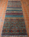 A great colouring has been used in this fine quality Afghan Samarkand runner. Predominantly different shades of blues, with old gold, tan, red and soft brown have been worked in to the design. The traditional geometric design is interspersed with plain bands of colour giving the piece a striking modern twist.