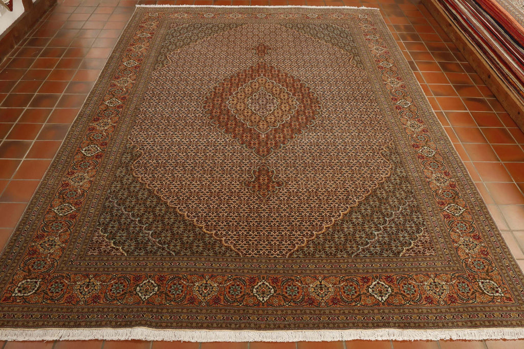 This is a stunning Persian Tabriz carpet in an intricate, ornate design. Hand knotted in north west Iran this complex design has been hand knotted using a wool pile on to a cotton foundation with silk highlights. The colour palatte is essentially a cream background with a soft salmon border. The corners to the central panel are a soft green and the central medallion is terracotta and peach.