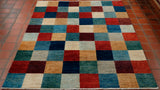 A chequerboard design across the entirety of the rug with blocks of turquoise, cream, sea blue/green, duck egg blue, red/orange golden yellow and burgundy. 