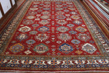 A fabulous Fine Kazak, 399 by 291 centimetres in size.  It comes with a rich red background, and bold geometric pattern in colours of light and dark blue, tangerine, cream and a bluey-green, terracotta and rust.  The borders a mix of the same palette , 5 bands deep with smaller geometric designs within each band.  The fineness of the detail is a sign of high-quality weaving.