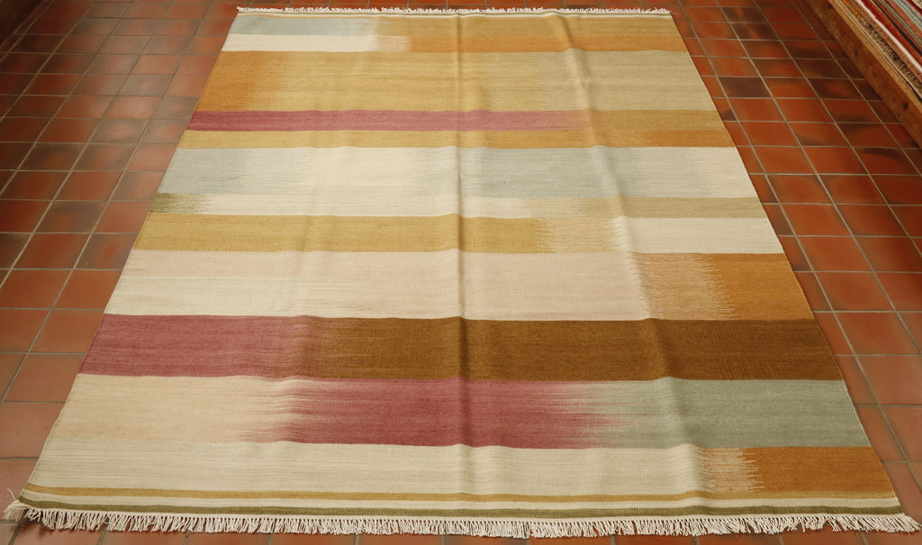 This Indian Kilim rug has bands of blended colour of varying width going across it horizontally.  These bands are in browns and tans, greens (light and dark), duck egg blue and dusky pink shades.  